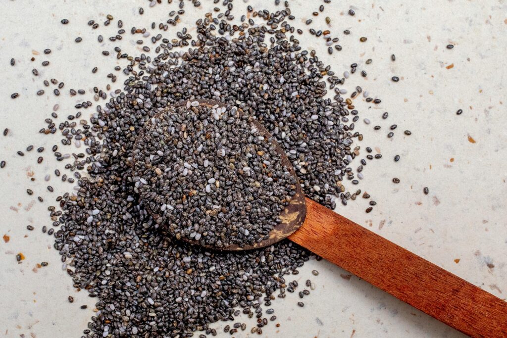 Wooden spoon filled with chia seeds, highlighting their texture and nutritional value.
